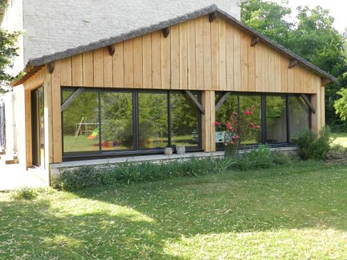 a screened in porch with windows on a house at La Maison des Escargots in Blanzay