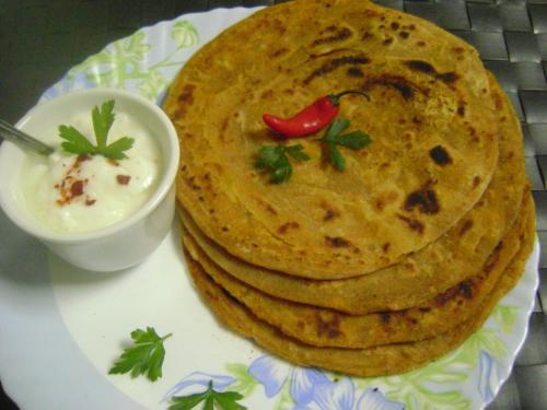 Ein Teller mit einem Stapel Naan-Brot und einer Schüssel Dip in der Unterkunft Blossom Dormitory For Male and Female in Mumbai