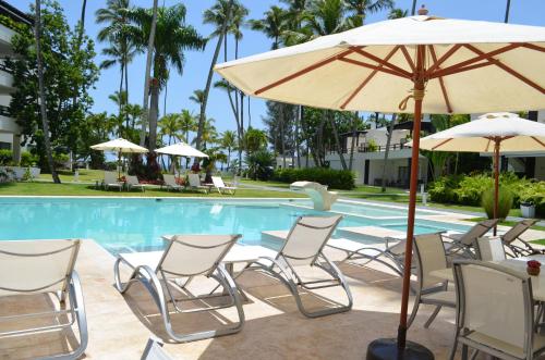 a group of chairs and umbrellas next to a pool at Aligio Beachfront Paradise in Las Terrenas