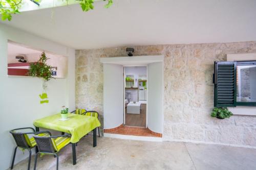 a dining room with a yellow table and chairs at Apartments Stinice in Gradac
