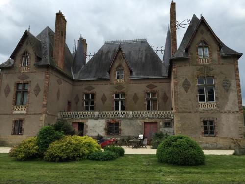 an old house with a large building with turrets at Manoir De La Chouanniere in Montreuil-sur-Maine