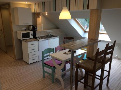 Báró Berg Apartman في كابوفار: مطبخ مع طاولة وكراسي في غرفة
