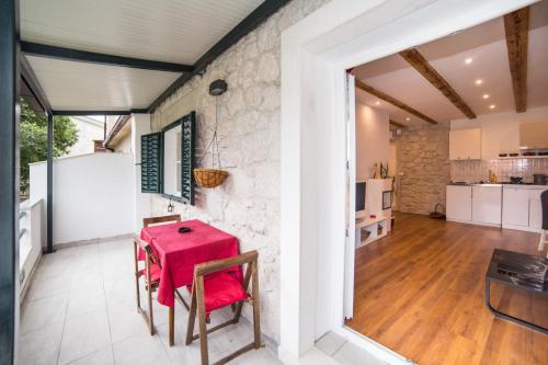 a kitchen and dining room with a red table and chairs at Apartments Stinice in Gradac
