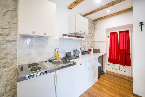 a kitchen with white cabinets and a sink at Apartments Stinice in Gradac