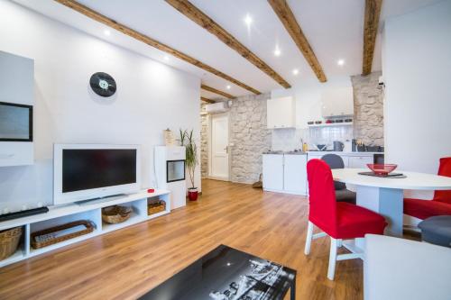 a kitchen and living room with a table and red chairs at Apartments Stinice in Gradac