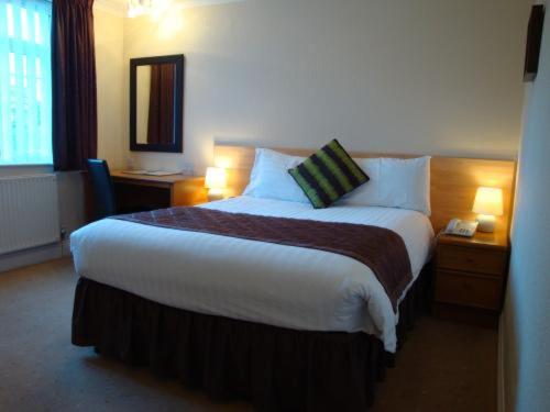a hotel room with a large bed and two lamps at Travelrest Fareham Solent Gateway in Fareham