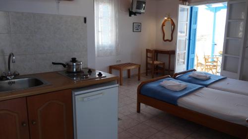a kitchen with a bed and a sink in a room at Hotel Hara in Naxos Chora