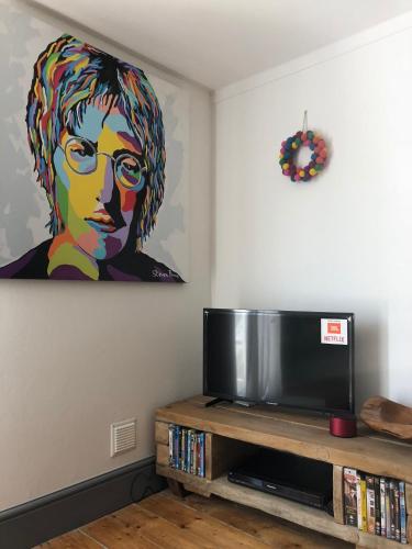 a living room with a painting of a woman at Central Tavira apartment with balcony, Casa Cristina in Tavira