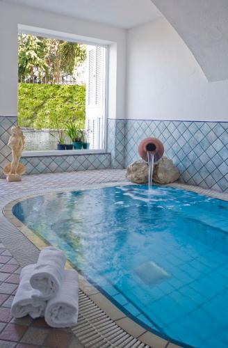 a swimming pool with a fountain in a room at Hotel Villa D'Orta in Ischia