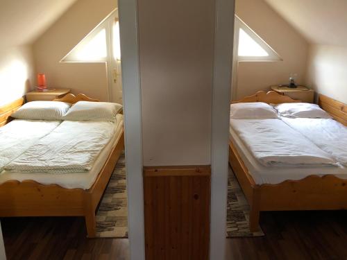 Dos camas en una habitación con dos ventanas. en Casuta -Maria-Kisház, en Sovata
