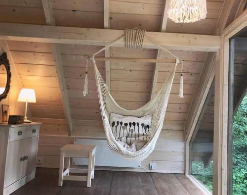 a hammock hanging from the ceiling of a cabin at Tahkuna Forest House in Kõrgessaare