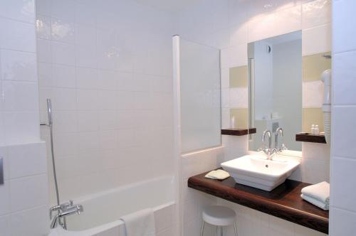 a white bathroom with a sink and a shower at Hôtel Au Logis des Remparts in Saint-Émilion