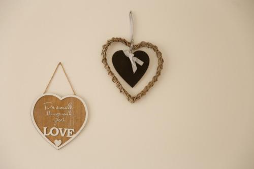 two heart ornaments hanging on a wall at Morzsi Apartman in Szilvásvárad