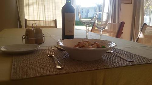a table with a bowl of food and a bottle of wine at Hotel Boutique Posada Piedras Blancas in Santa Rosa