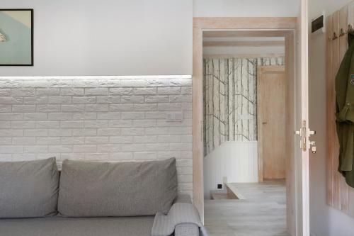 a living room with a couch and a brick wall at Aloza in Ustka