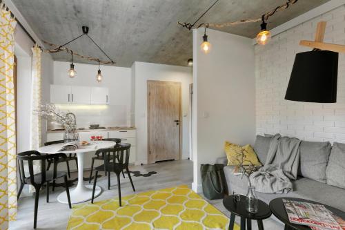 a kitchen and living room with a table and a couch at Aloza in Ustka
