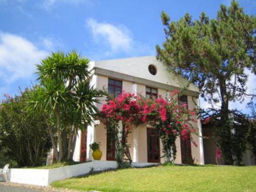 ein weißes Haus mit rosa Blumen davor in der Unterkunft Odeceixe Bungalow-Parque de Campismo Sao Miguel in Odeceixe