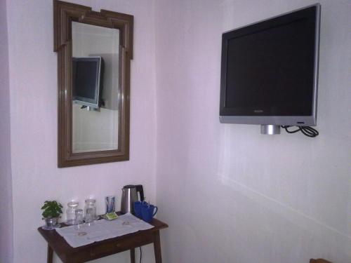 TV de pantalla plana colgada en una pared con mesa en Short Stay De Rode Kers, en Harlingen