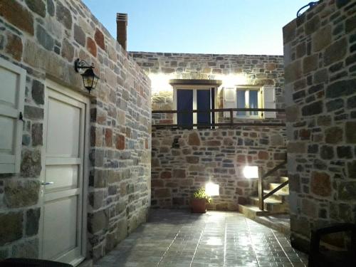 a stone building with a door and a balcony at Amfi Sea View in Frý