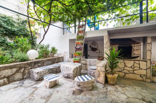 a patio with three stools and a fireplace at Apartments Stinice in Gradac