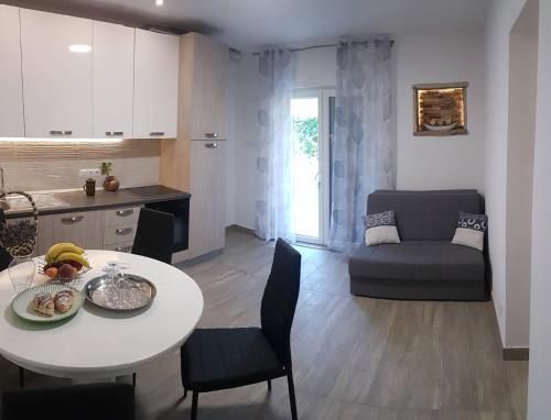 cocina y sala de estar con mesa y sillas. en Niko apartment, en Jelsa