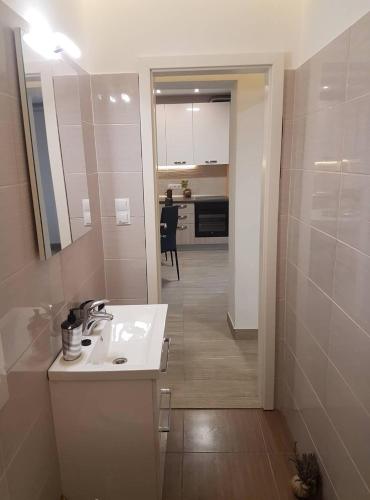 a white bathroom with a sink and a kitchen at Niko apartment in Jelsa
