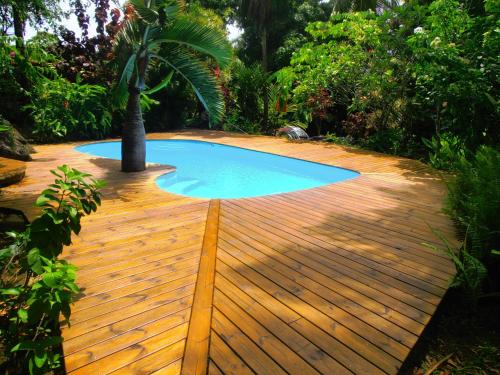 a small swimming pool on a wooden deck at Les Manguiers in Deshaies