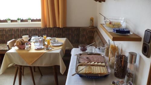 uma sala de jantar com duas mesas e uma mesa com comida em Gästehaus Tramnitz em Mayrhofen