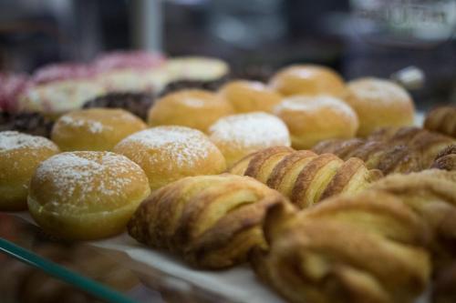 un assortiment de beignets et de pâtisseries exposés dans une boulangerie dans l'établissement Hotel Aurora, à Lignano Sabbiadoro