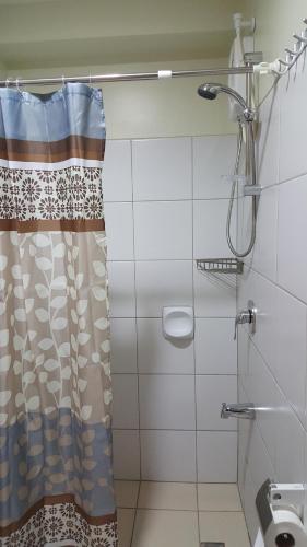 a shower in a bathroom with a shower curtain at Khalil's Horizons 101 Studio Type Condominium in Cebu City