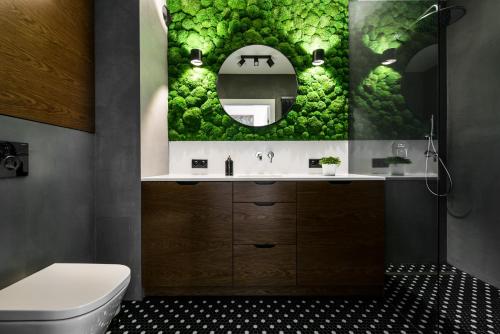 a bathroom with a sink and a mirror at Moss Apartment in Krakow