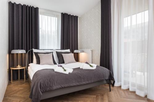 a bedroom with a large bed with two towels on it at Moss Apartment in Krakow