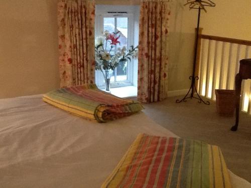 a bed with a blanket on it in a room at 5 High Street in Temple Combe