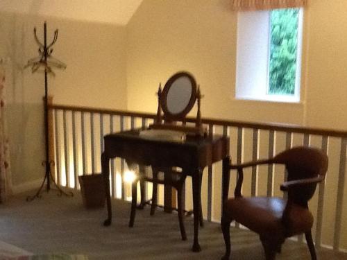 a mirror sitting on top of a piano in a room at 5 High Street in Temple Combe