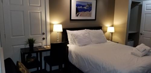 a bedroom with a white bed with two lamps at Gondola Lodge & Tahoe Beach Club in South Lake Tahoe
