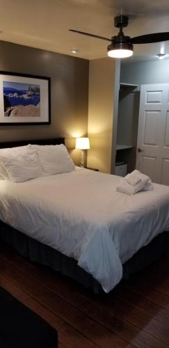 a bedroom with a large white bed with a ceiling fan at Gondola Lodge & Tahoe Beach Club in South Lake Tahoe