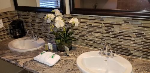 two sinks in a bathroom with flowers on a counter at Gondola Lodge & Tahoe Beach Club in South Lake Tahoe