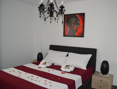 a bedroom with a large bed with a painting on the wall at Villa Mare in Klek