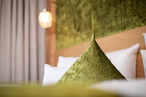 a green pillow sitting on top of a bed at Wagner's Aparthotel in Pertisau