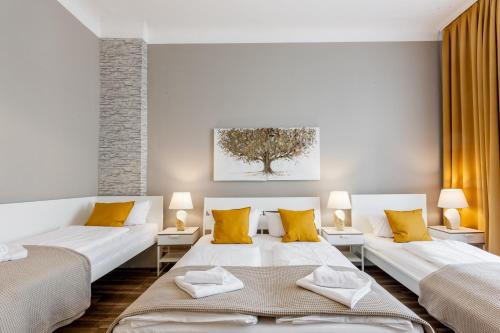 ベルリンにあるDilo Apartments - MyGold Apartment 120 SQMのリビングルーム(ベッド2台、黄色い枕付)
