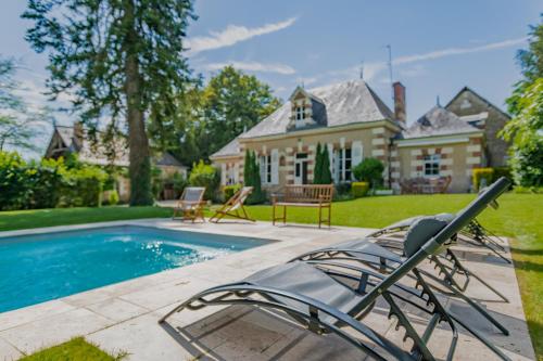 une cour arrière avec une piscine et une maison dans l'établissement Ancien pavillon de chasse du château de Chaumont sur Loire, à Chaumont-sur-Loire