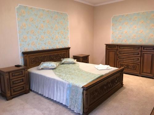 a bedroom with a bed and two dressers at Дворівневі Апартаменти Antique in Ternopilʼ