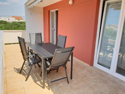- une table à manger et des chaises sur le balcon d'une maison dans l'établissement Apartment Nevena, à Betina