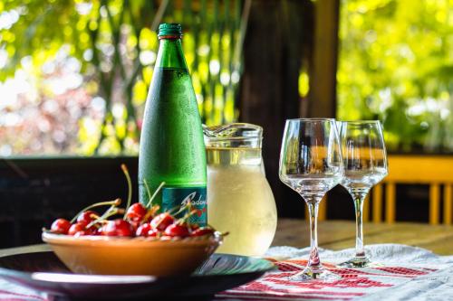 a table with two wine glasses and a bowl of cherries at Challet Bella in Poljanica Bistranska