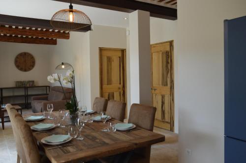 a dining room with a wooden table and chairs at Les Gîtes Du Clos D'Olea in Oppède