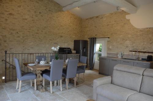 a kitchen and dining room with a table and chairs at Les Gîtes Du Clos D'Olea in Oppède