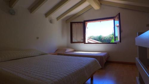 1 dormitorio con 2 camas y ventana en Lavu Santu en Sainte-Lucie de Porto-Vecchio