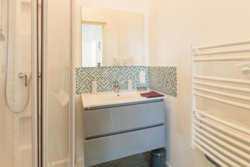 La salle de bains est pourvue d'un lavabo et d'un miroir. dans l'établissement Le 39, à Isigny-sur-Mer