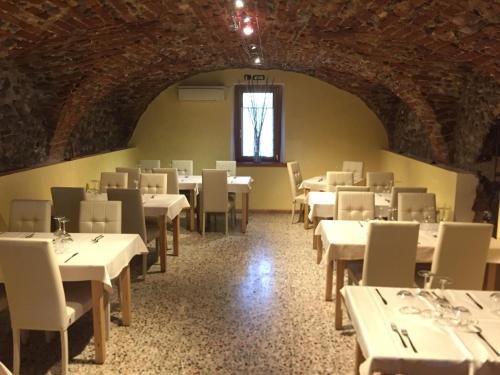 a dining room with white tables and chairs and a window at Agriturismo Casa Villi in Solferino