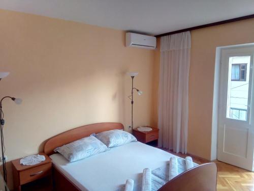Apartment Luka في ماكارسكا: غرفة نوم بسرير ابيض ونافذة